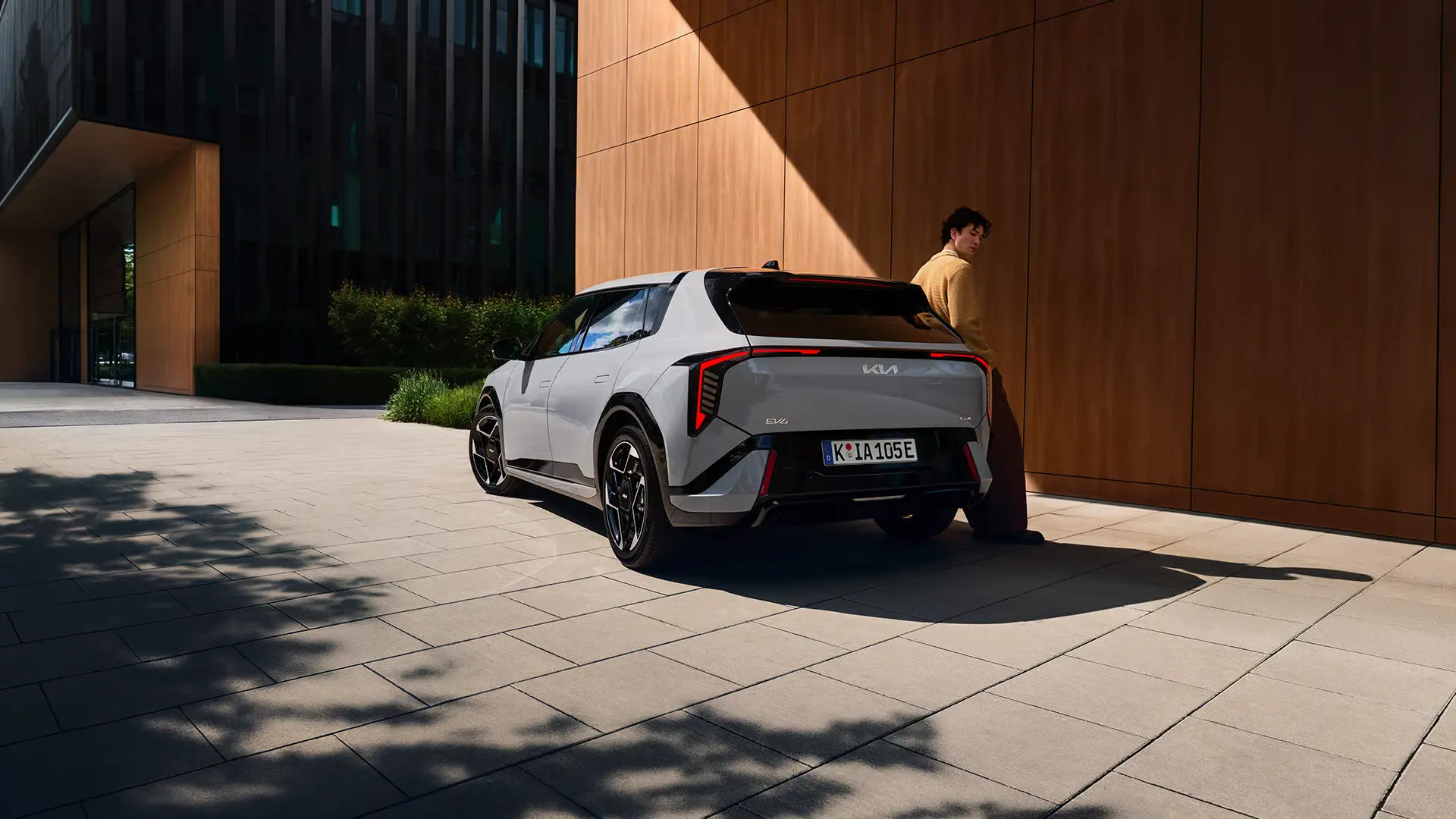 kia-ev4-my26-NA-Beauty_34-Rear_MaleTalent_rgb-1920x1080 Kia EV4 grå - miljøbillede skråt bagfra